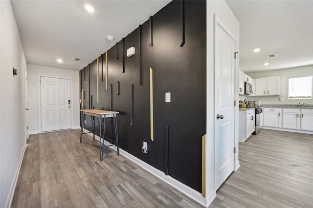 hallway featuring light wood-type flooring and sink