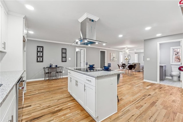 kitchen featuring white cabinetry, island exhaust hood, a center island, light stone countertops, and black electric cooktop