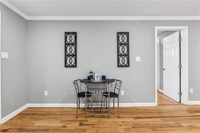 dining room with wood-type flooring and ornamental molding