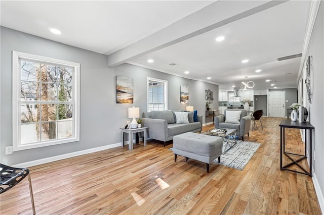 living room featuring beam ceiling, light hardwood / wood-style flooring, and ornamental molding