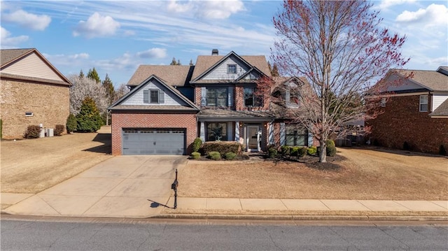 view of front facade with a front lawn, brick siding, a chimney, and driveway