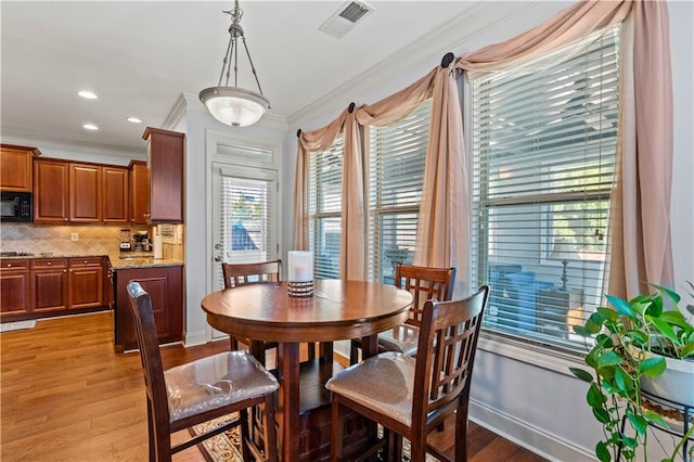 dining area featuring baseboards, visible vents, light wood finished floors, recessed lighting, and crown molding