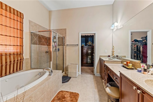 bathroom featuring vanity, a stall shower, tile patterned flooring, and a bath