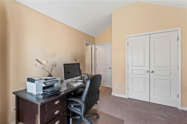 carpeted home office featuring baseboards and vaulted ceiling