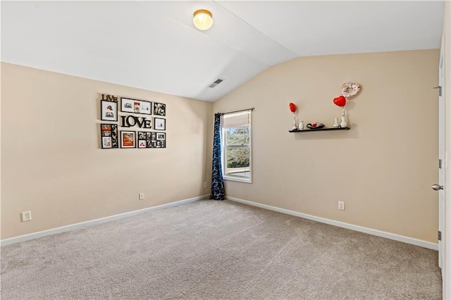 unfurnished room with vaulted ceiling, carpet flooring, baseboards, and visible vents