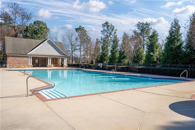 pool featuring a patio area, an outdoor structure, and fence