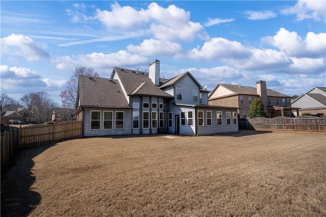 back of house with a residential view, a lawn, a shingled roof, and a fenced backyard