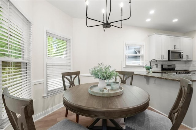 dining area featuring baseboards, a chandelier, wood finished floors, and recessed lighting