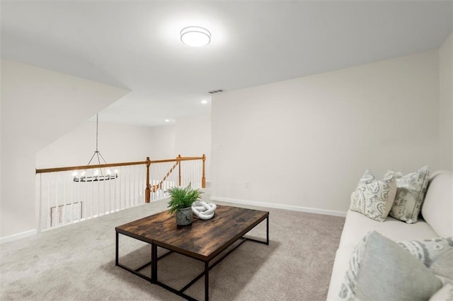 carpeted living room featuring a chandelier and baseboards
