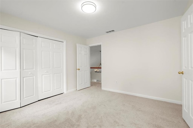 unfurnished bedroom featuring carpet, baseboards, and a closet