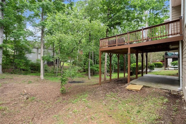view of yard featuring a wooden deck and a patio area