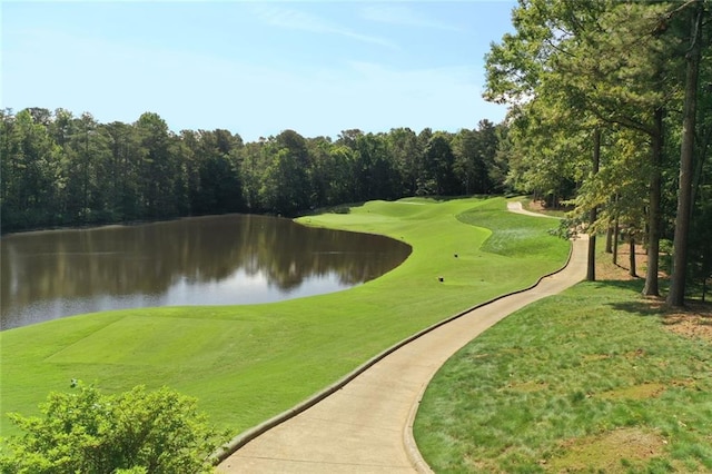 surrounding community featuring a water view, a lawn, and view of golf course