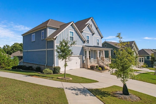 craftsman-style house with a garage, a front yard, and covered porch