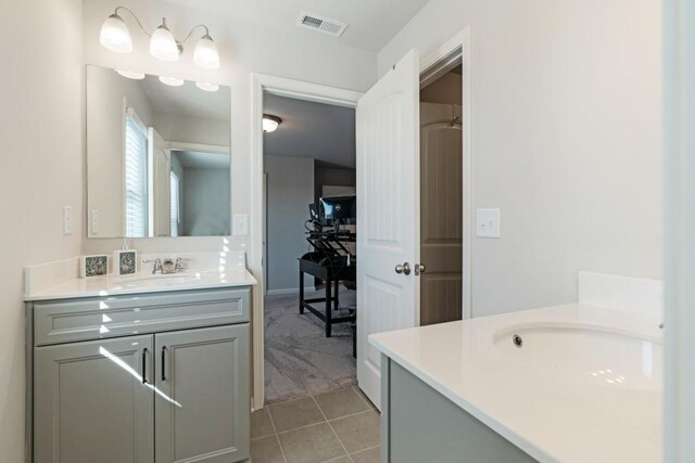 kitchen with pendant lighting, appliances with stainless steel finishes, gray cabinetry, a kitchen breakfast bar, and a kitchen island