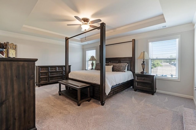 carpeted bedroom with a raised ceiling and ornamental molding