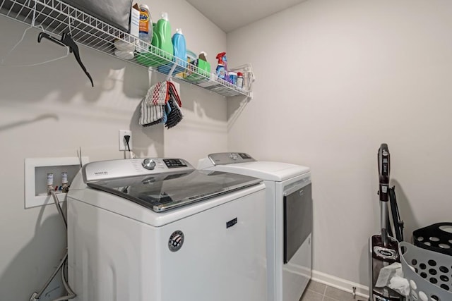 laundry room featuring light tile patterned floors and washing machine and dryer