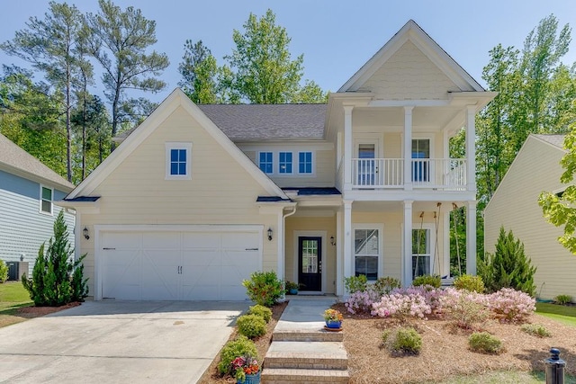 view of front facade featuring a garage, driveway, and a balcony