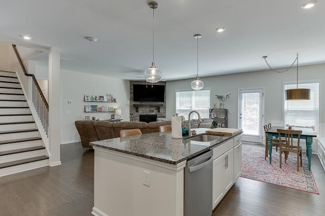 kitchen with a sink, a fireplace, dark wood-style floors, and dishwasher