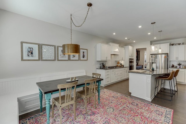 kitchen with white cabinets, stainless steel appliances, decorative backsplash, and custom range hood
