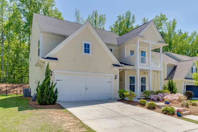 view of front of property featuring driveway, a garage, central AC, fence, and a balcony