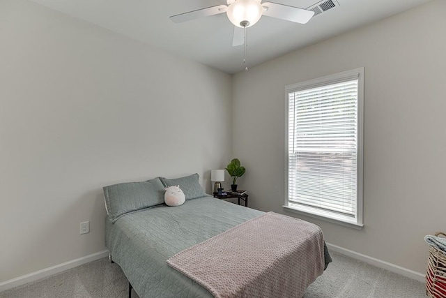carpeted bedroom with a ceiling fan, baseboards, visible vents, and multiple windows