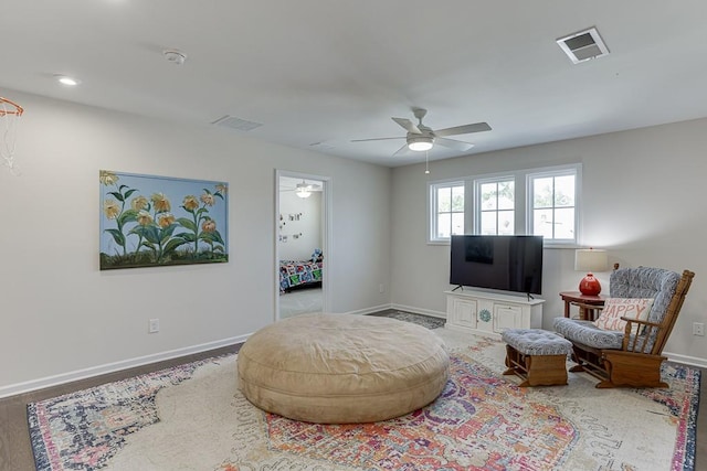 living area featuring a ceiling fan, baseboards, and visible vents