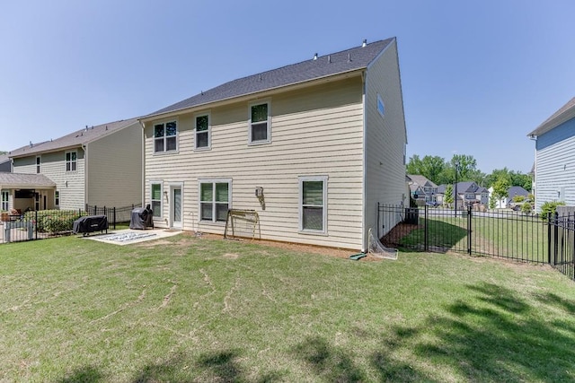 rear view of property featuring a yard, a residential view, a fenced backyard, and a patio area