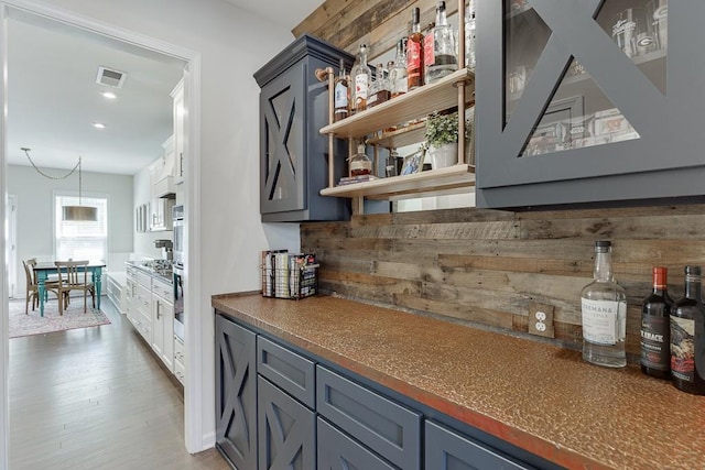 bar with recessed lighting, a dry bar, wood finished floors, and visible vents