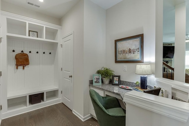 mudroom with visible vents, dark wood finished floors, baseboards, and built in study area