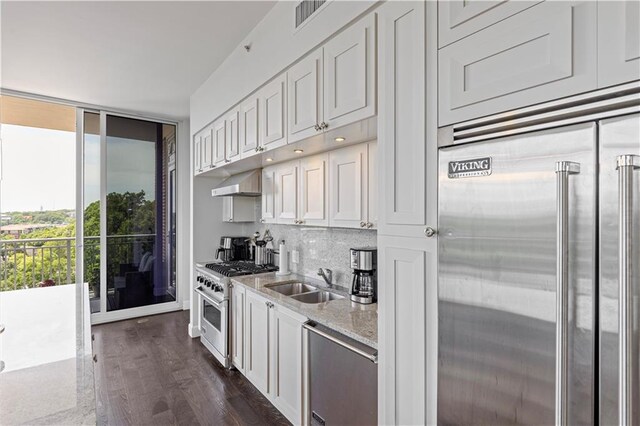1820 Peachtree St Unit 614, Atlanta, GA 30309 - kitchen with high end appliances, a sink, backsplash, dark wood-style floors, and light stone counters