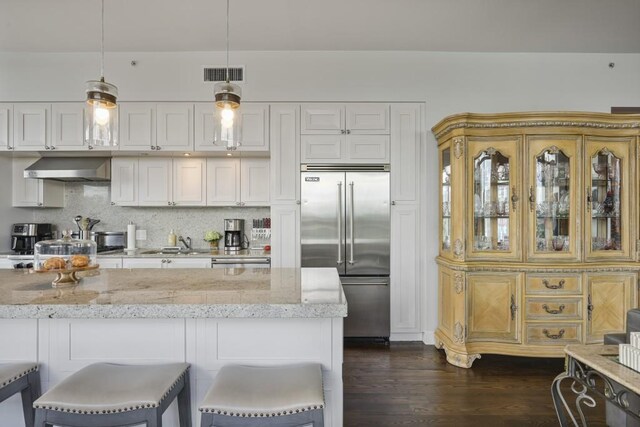 1820 Peachtree St Unit 614, Atlanta, GA 30309 - kitchen featuring stainless steel built in fridge, exhaust hood, a sink, light stone counters, and dark wood finished floors