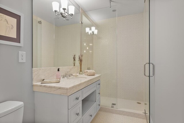 1820 Peachtree St Unit 614, Atlanta, GA 30309 - bathroom with a chandelier, toilet, vanity, a stall shower, and tile patterned flooring