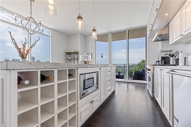 1820 Peachtree St Unit 614, Atlanta, GA 30309 - kitchen with stainless steel appliances, floor to ceiling windows, dark wood-type flooring, white cabinetry, and light stone counters