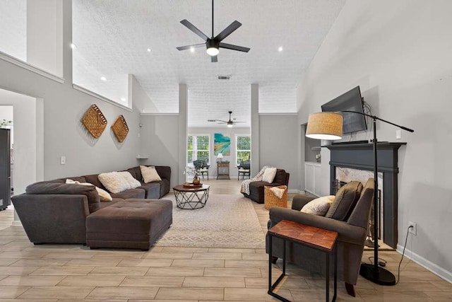 734 Evergreen Dr, Winder, GA 30680 - living area with ceiling fan, a fireplace, a high ceiling, wood finish floors, and a textured ceiling