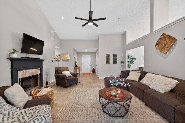 734 Evergreen Dr, Winder, GA 30680 - living room with high vaulted ceiling, light wood finished floors, a ceiling fan, and a fireplace