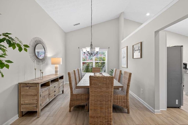 734 Evergreen Dr, Winder, GA 30680 - dining space featuring light wood-style floors, a chandelier, and high vaulted ceiling