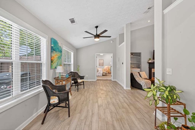 734 Evergreen Dr, Winder, GA 30680 - sitting room featuring ceiling fan, vaulted ceiling, light wood-type flooring, and a textured ceiling
