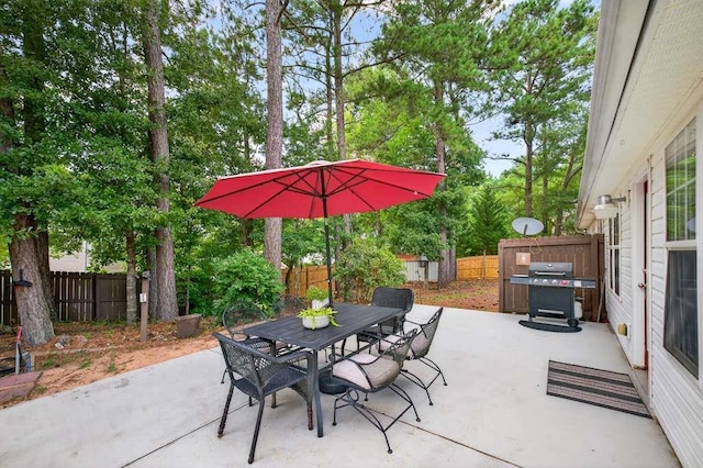 734 Evergreen Dr, Winder, GA 30680 - fenced backyard featuring area for grilling, a patio, outdoor dining area, a shed, and view of wooded area