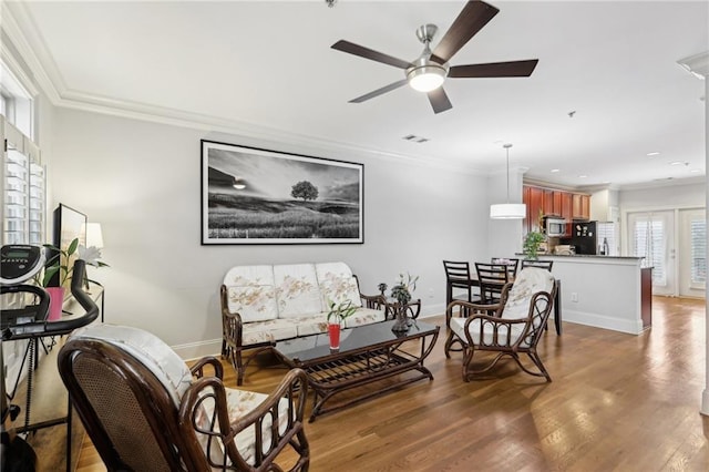 living room with ornamental molding, ceiling fan, and dark hardwood / wood-style flooring