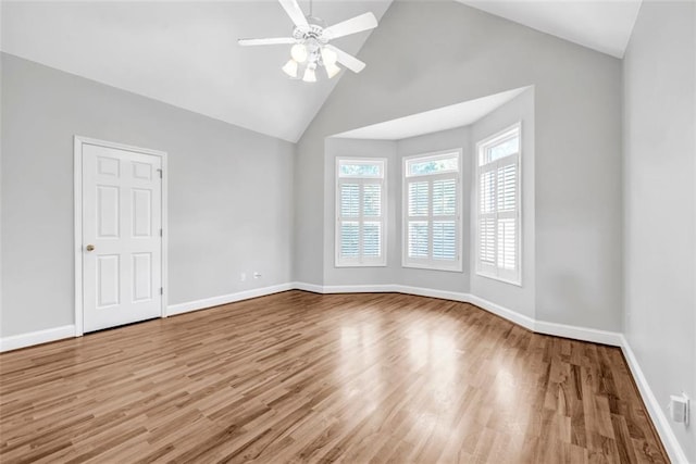 empty room featuring ceiling fan, high vaulted ceiling, and hardwood / wood-style floors