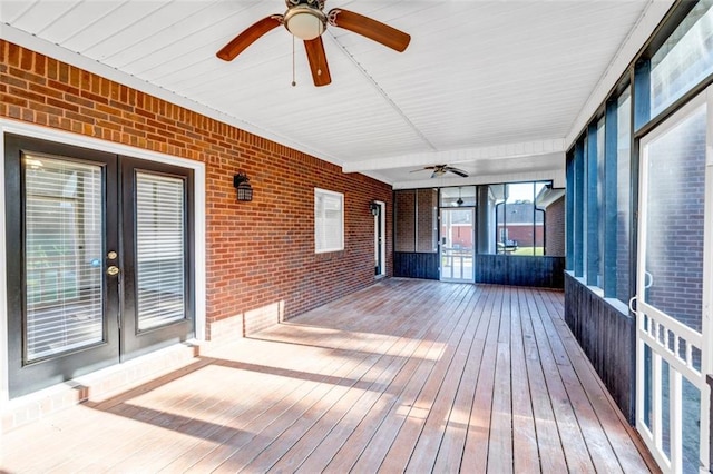 unfurnished sunroom featuring ceiling fan and french doors