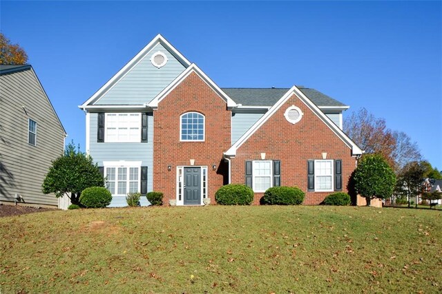 view of property featuring a front yard and a garage