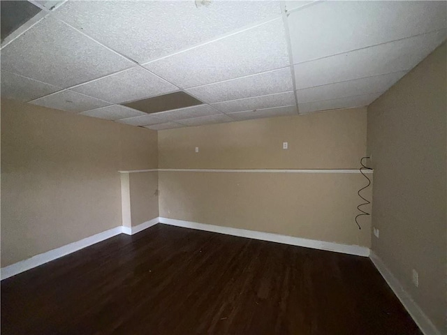 finished basement featuring wood finished floors, a drop ceiling, and baseboards