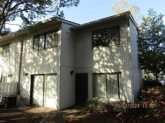 back of house with central AC unit and a garage