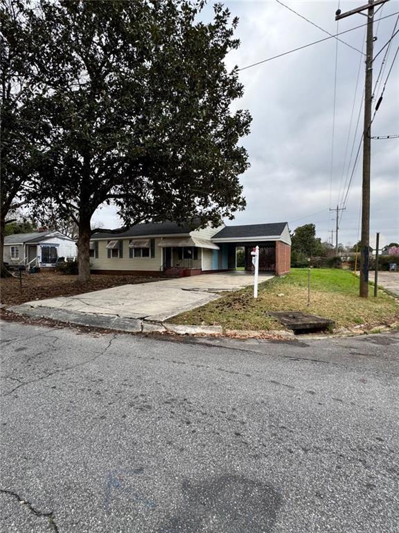 view of front of home with concrete driveway and an attached carport