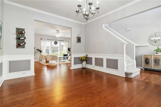 2319 White Alder Dr, Buford, GA 30519 - unfurnished living room featuring crown molding, stairs, a decorative wall, ceiling fan with notable chandelier, and wood finished floors