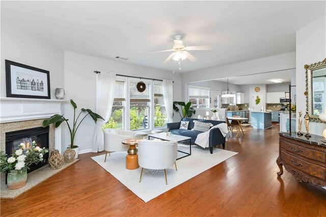 2319 White Alder Dr, Buford, GA 30519 - living area featuring wood finished floors, ceiling fan, baseboards, and a glass covered fireplace