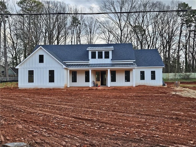 modern farmhouse featuring a porch, board and batten siding, a standing seam roof, and a shingled roof