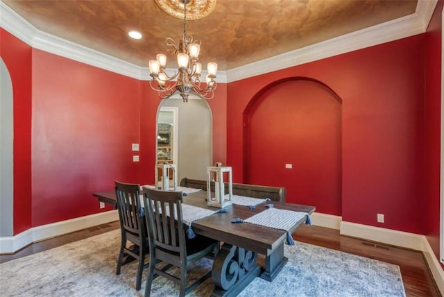 dining area featuring a chandelier, wood-type flooring, and crown molding