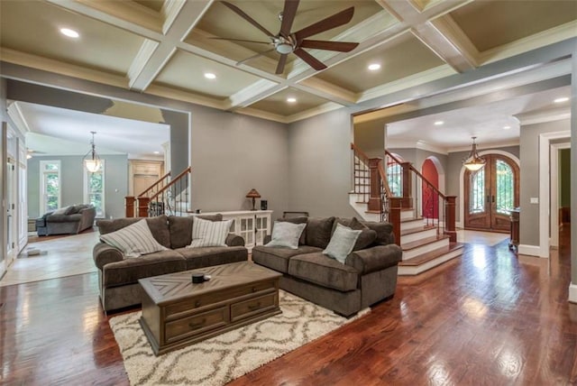 living room featuring coffered ceiling, ceiling fan, and a healthy amount of sunlight